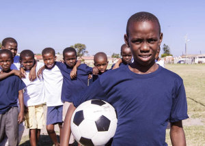 Children posing with soccer ball